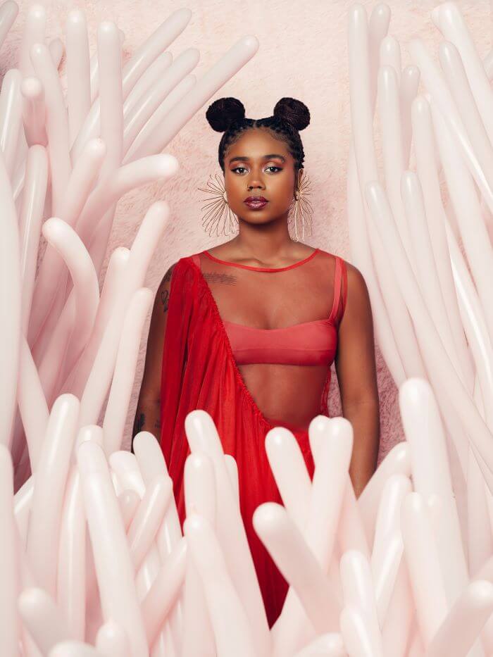Mulher de vermelho em cenário rosa 