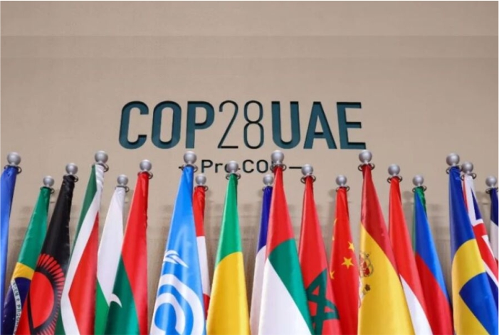 Bandeiras de vários país com logotipo da COP 28 ao fundo