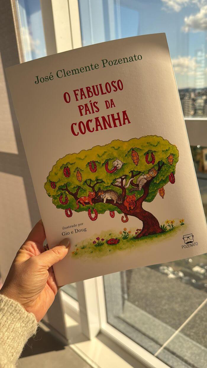 Pessoa segurando livro em frente à janela