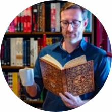 Homem segurando livro e café