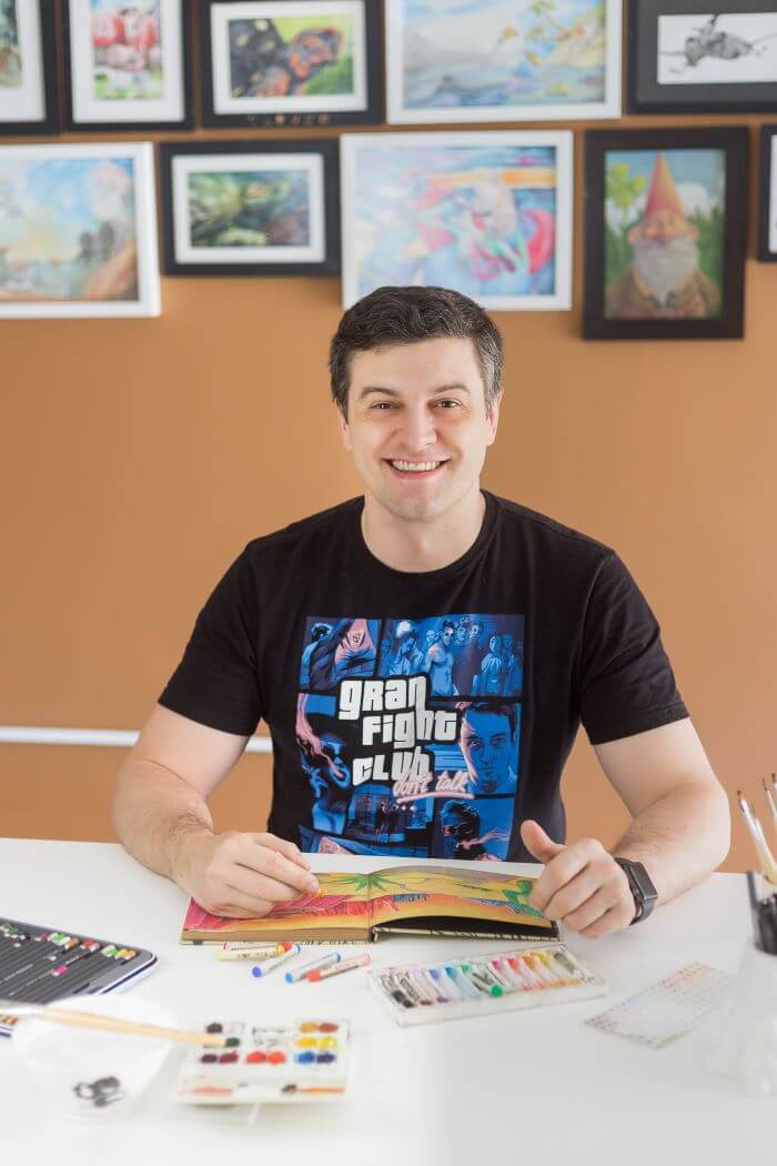 Professor sentado com livros de colorir