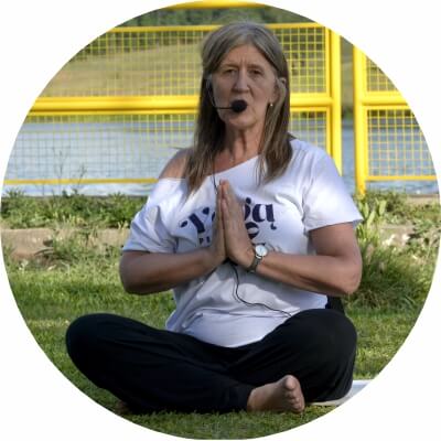 Mulher sentada ministrando aula de yoga