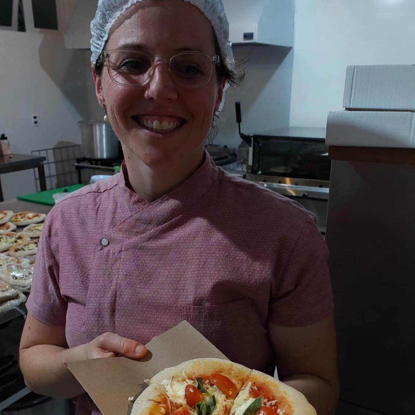 Mulher segurando pizza com massa de fermentação natural