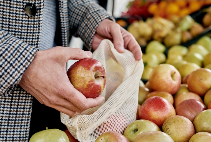 Pessoa comprando maçã orgânica