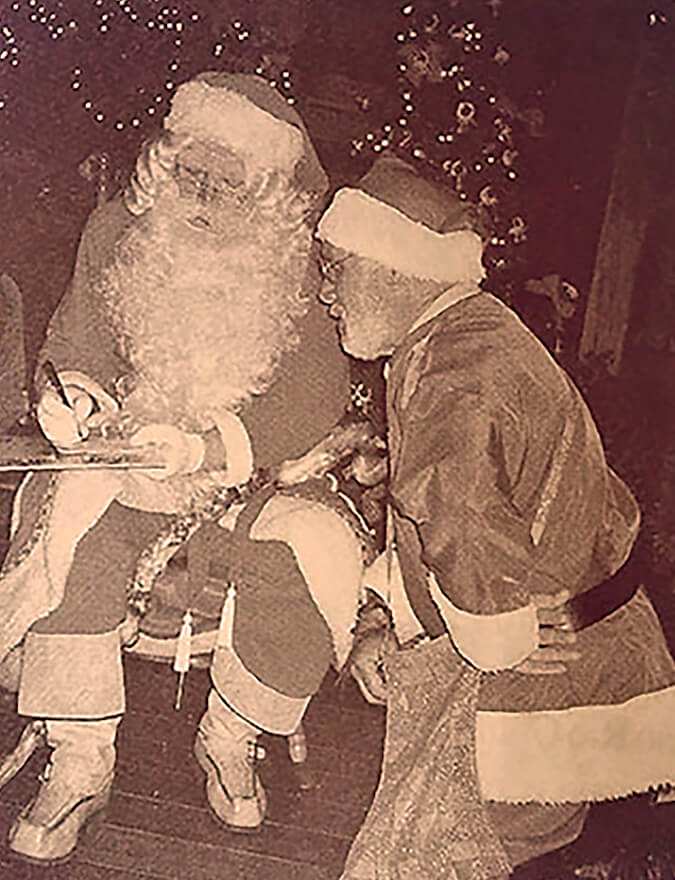 Dois homens vestidos de Papai Noel juntos