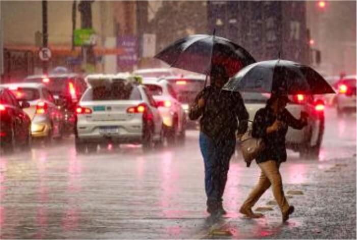 Duas pessoas de guarda chuva durante temporal