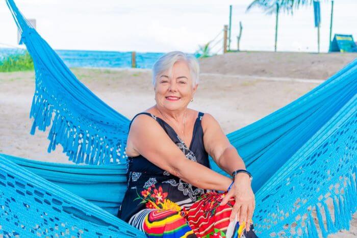 Senhora sentada em rede na praia