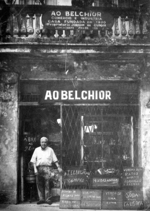 Foto em preto e branco de homem em frente a loja