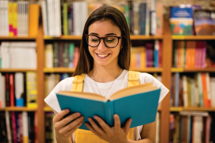 Mulher lendo livro e sorrindo