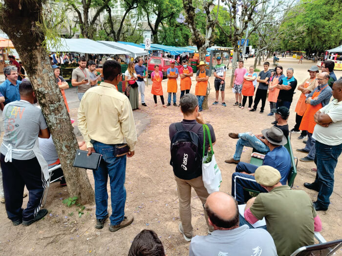 Pessoas reunidas em círculo na Feira Ecológica