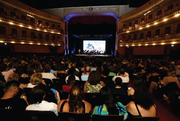 Plateia assistindo espetáculo em teatro