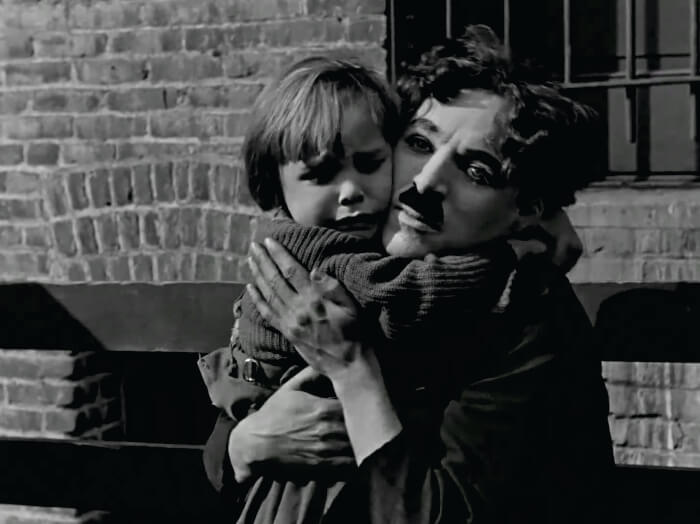 Charlie Chaplin abraçando criança