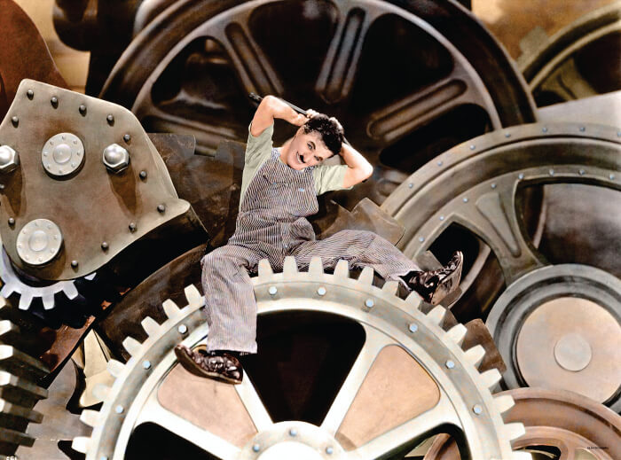 Charlie Chaplin em cima de engrenagens industriais