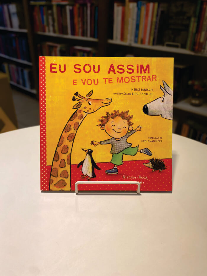 Livro de capa amarela com animais e criança