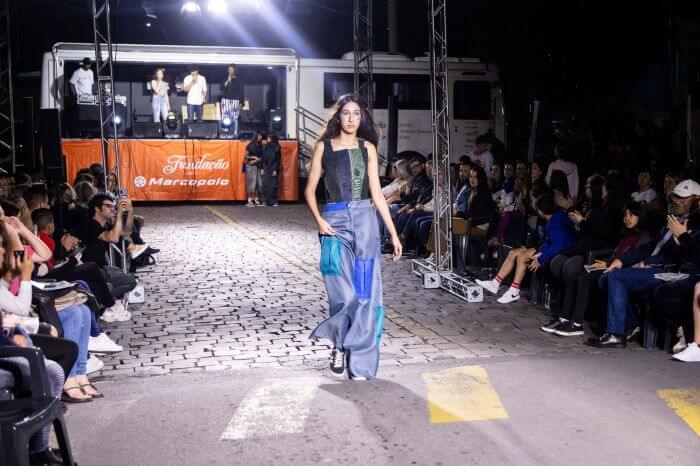 Menina desfilando em passarela na rua