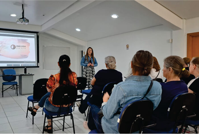 Pessoas sentadas assistindo à palestra