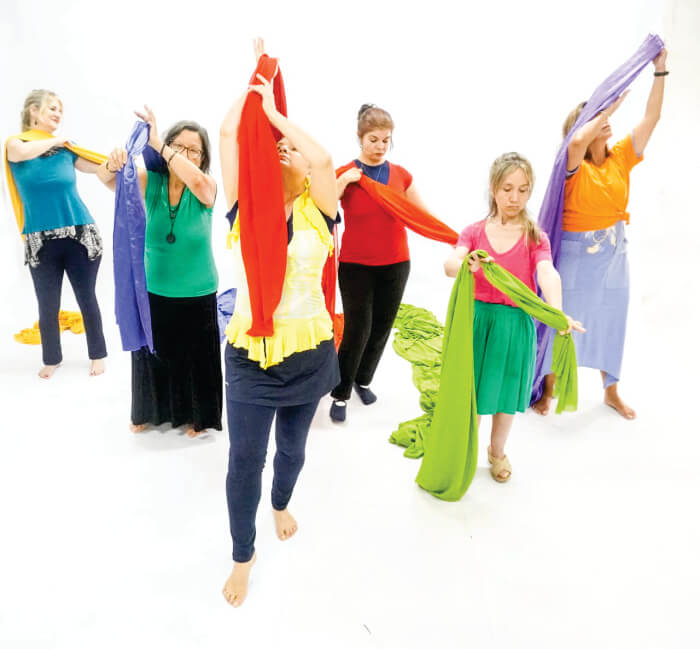 Mulheres dançando com tecidos coloridos