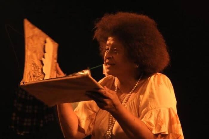 Mulher lendo livro em palco
